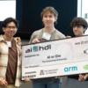 Four students from the team AI or Die hold and oversized check. 