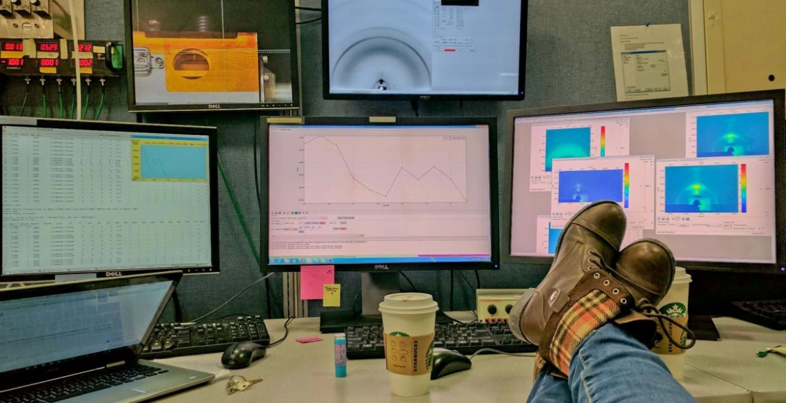 photo of feet on table, in front of computer screens